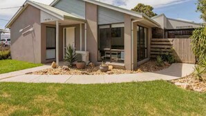 A modern single-story house with a sloped roof, large windows, and a front porch. - Beach House Getaway #2 (Smiths Beach)