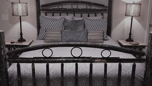 A bed with a wooden frame, patterned bedding, and two bedside lamps. - Have a "Hakuna Matata" apline vacation in Style & Luxury!! (Helen)
