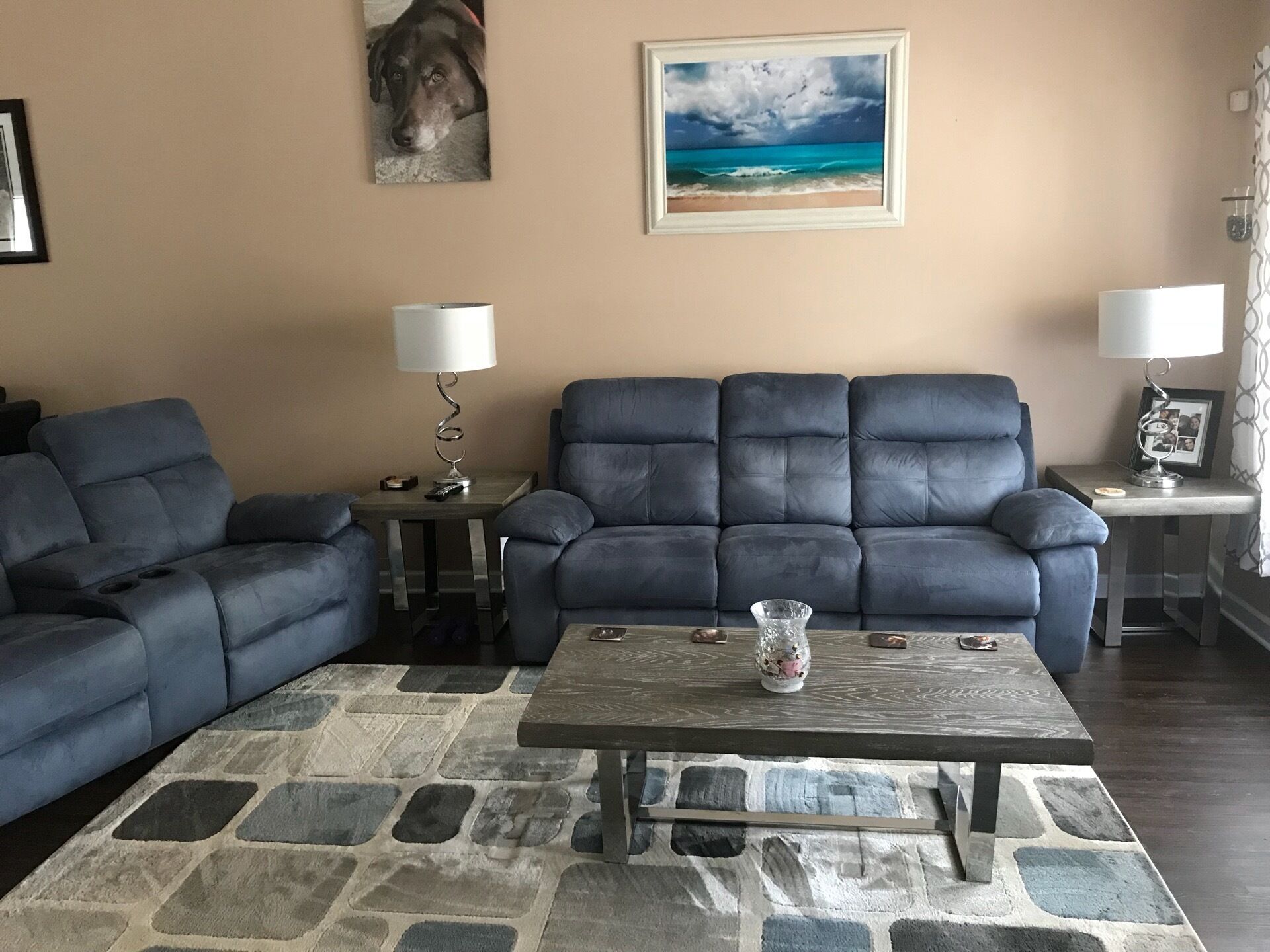 Un salon avec un canapé bleu foncé, une table basse et un tapis à motifs de pierre.