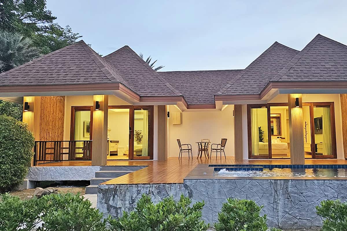 Uma casa moderna com piscina, deck de madeira e parede de pedra.