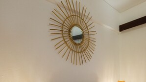 A bedroom with a bed, two bedside lamps, a decorative wall mirror, and patterned pillows. - Direct & Private beach access. 30 km from Lisbon (Sesimbra)