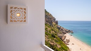 A balcony with a white wall and a decorative light fixture. - Direct & Private beach access. 30 km from Lisbon (Sesimbra)