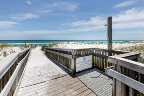 A wooden boardwalk leading to a beach with a sign warning against leaving items on the beach. - GD 215: White Sand Wonders - Life’s a Beach so Live it in Style! (Fort Walton Beach)