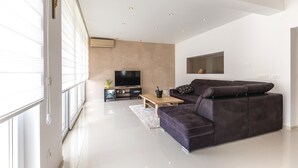 A modern living room with a large sectional sofa, a flat-screen TV, and a minimalist design. - Stunning home in Glavina Donja (Glavina Donja)