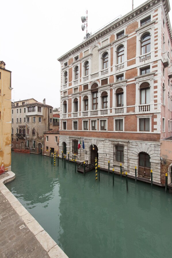 A canal with buildings on either side, including a prominent building with multiple windows and balconies.