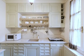 Kitchen features a sink, microwave, and ample storage for kitchen essentials.