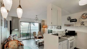Een compacte wooneenheid met kitchenette, eethoek en balkon met uitzicht.