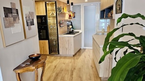 Une cuisine moderne avec des meubles en bois, un four encastré et un meuble à vin avec une façade en verre.