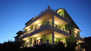 Un immeuble à plusieurs étages, doté de balcons et d’une façade verdoyante.
