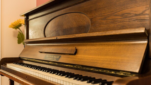 Un piano à queue avec un placage en bois et une étiquette sur le devant.