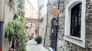 A narrow alleyway with stone buildings, a sign for 'Casa Vacanze', and wrought iron gates. - "A TASTE OF PROVENCE" Among Olive Trees and the Sea (Terzorio)