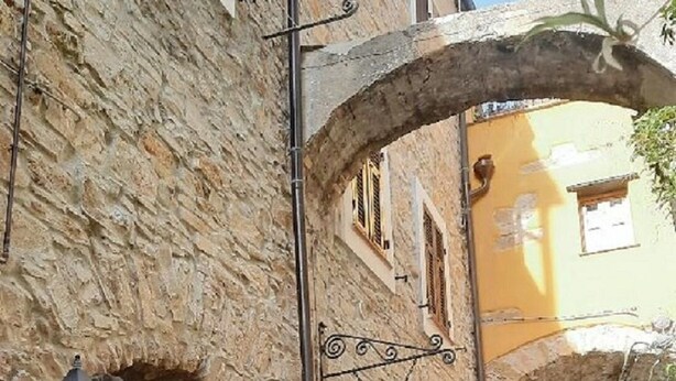 A narrow stone street with a wrought iron gate and a sign indicating a vacancy. - "A TASTE OF PROVENCE" Among Olive Trees and the Sea (Terzorio)