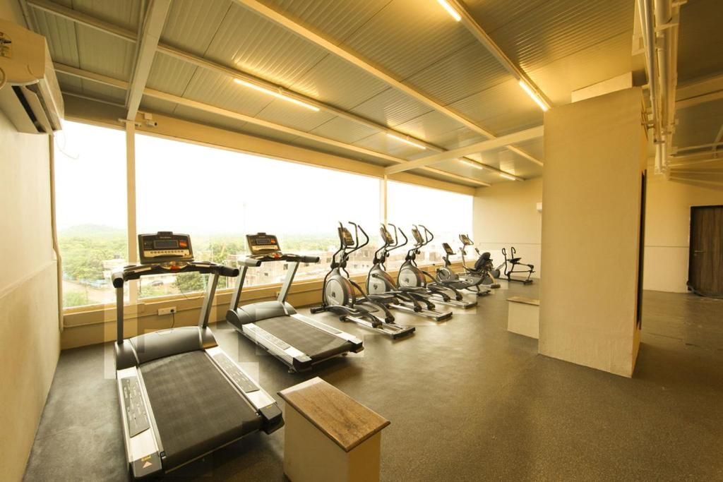 Ein Fitnessraum mit in Reihen angeordneten Laufbändern und Ergometer.