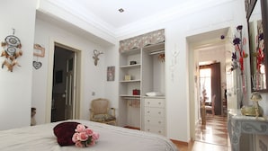 Une chambre à coucher avec un lit, une armoire, une chaise et un miroir.