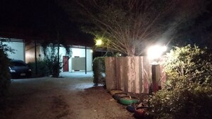 A dimly lit driveway leading to a building with a car parked nearby. - Dome Resort (Sena)