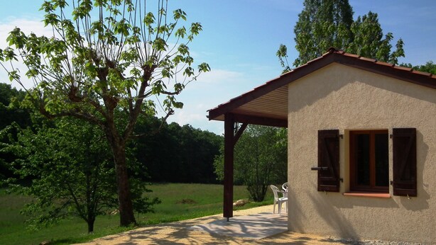 A small building with a sloped roof and wooden shutters, surrounded by trees and a clear sky. - Little House with beautiful view in unique Holiday Resort **** in Dordogne-Lot (Gavaudun)
