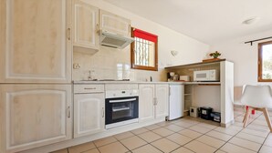 A kitchen with a built-in oven, a microwave, and a coffee maker. - Little House with beautiful view in unique Holiday Resort **** in Dordogne-Lot (Gavaudun)