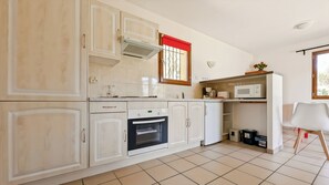 Eine Küche mit Backofen, Mikrowelle und Kaffeemaschine.