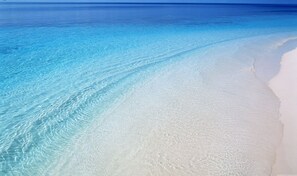 Una platja amb aigua turquesa cristal·lina i sorra blanca.