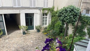 A courtyard with a cobblestone floor, potted plants, and a variety of flowers. - 4 ROOMS COZY, FUNCTIONAL, 4/5 pers NEAR TOUR EIFFEL St GERMAIN ... (Paris)