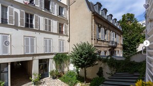 A courtyard with a stone staircase, a tree, and a building with multiple windows and balconies. - 4 ROOMS COZY, FUNCTIONAL, 4/5 pers NEAR TOUR EIFFEL St GERMAIN ... (Paris)