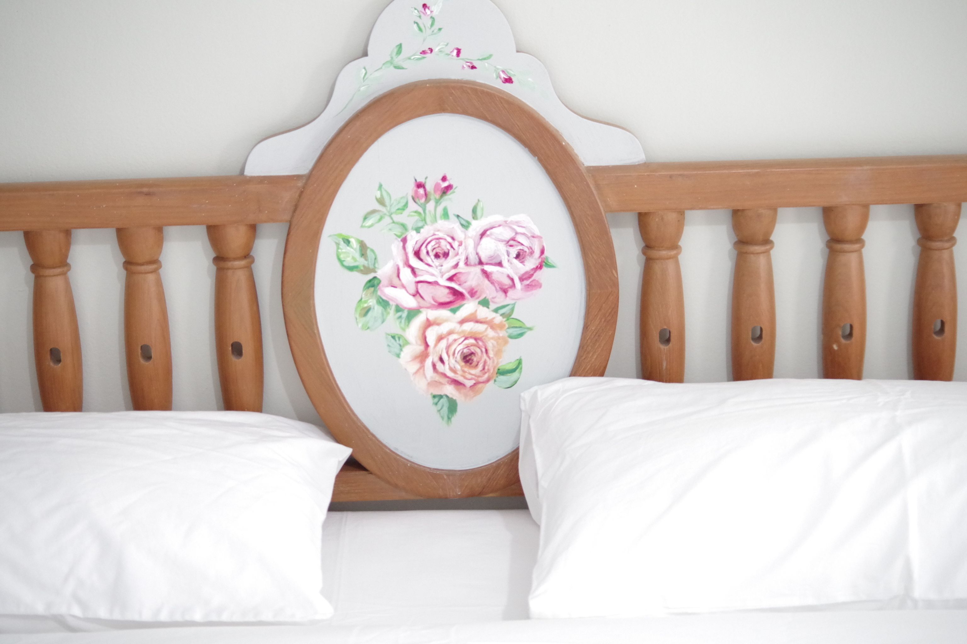 A bed with white bedding and a wooden headboard.