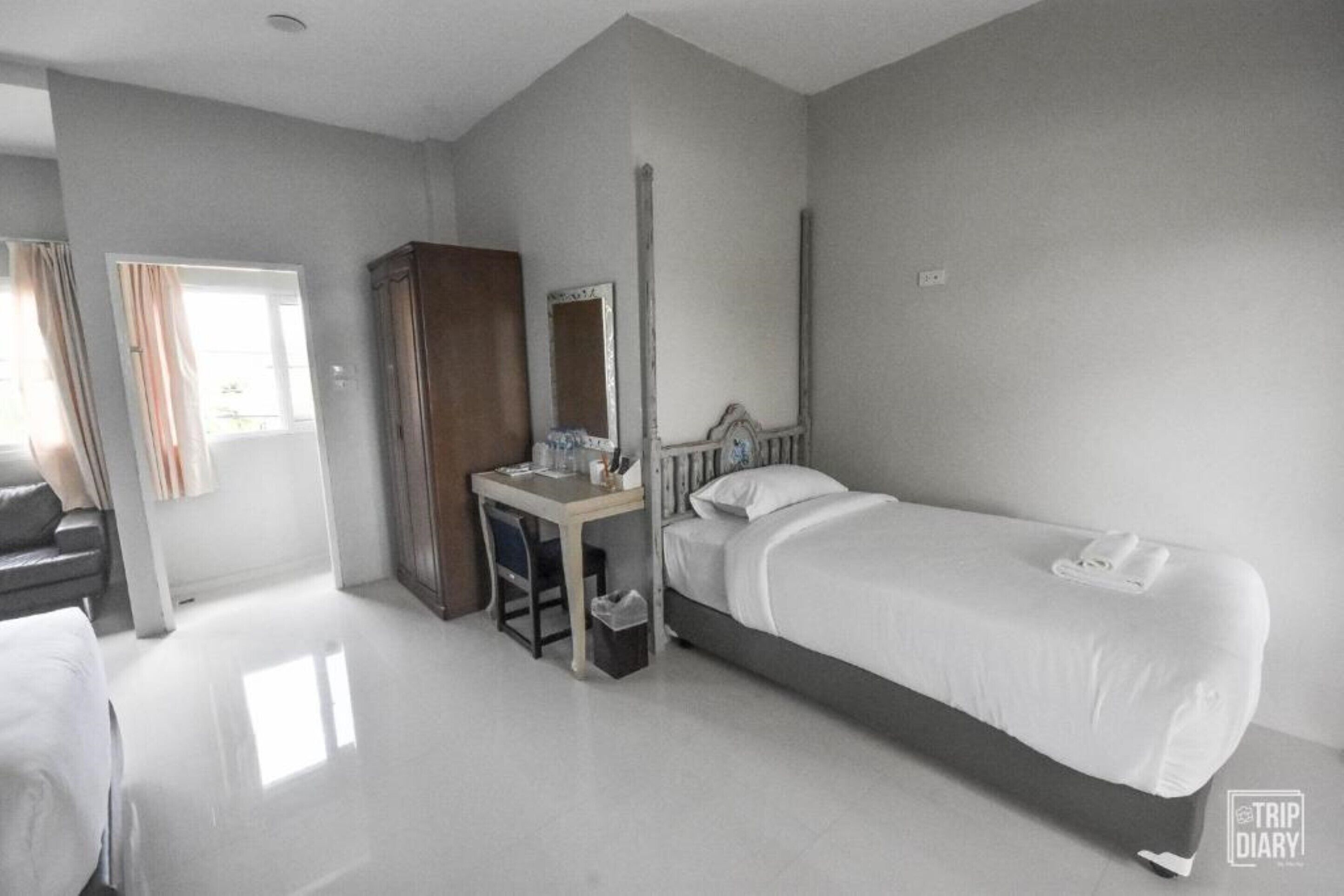 Habitación de hotel con cama, escritorio, armario y espejo.