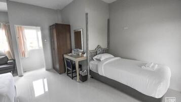 Habitación de hotel con cama, escritorio, armario y espejo.