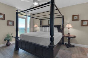A four-poster bed with a canopy, two bedside lamps, a small round table, and a potted plant. - Aqua 1711 - 2B/2 Bath Gulf Front! (Panama City Beach)