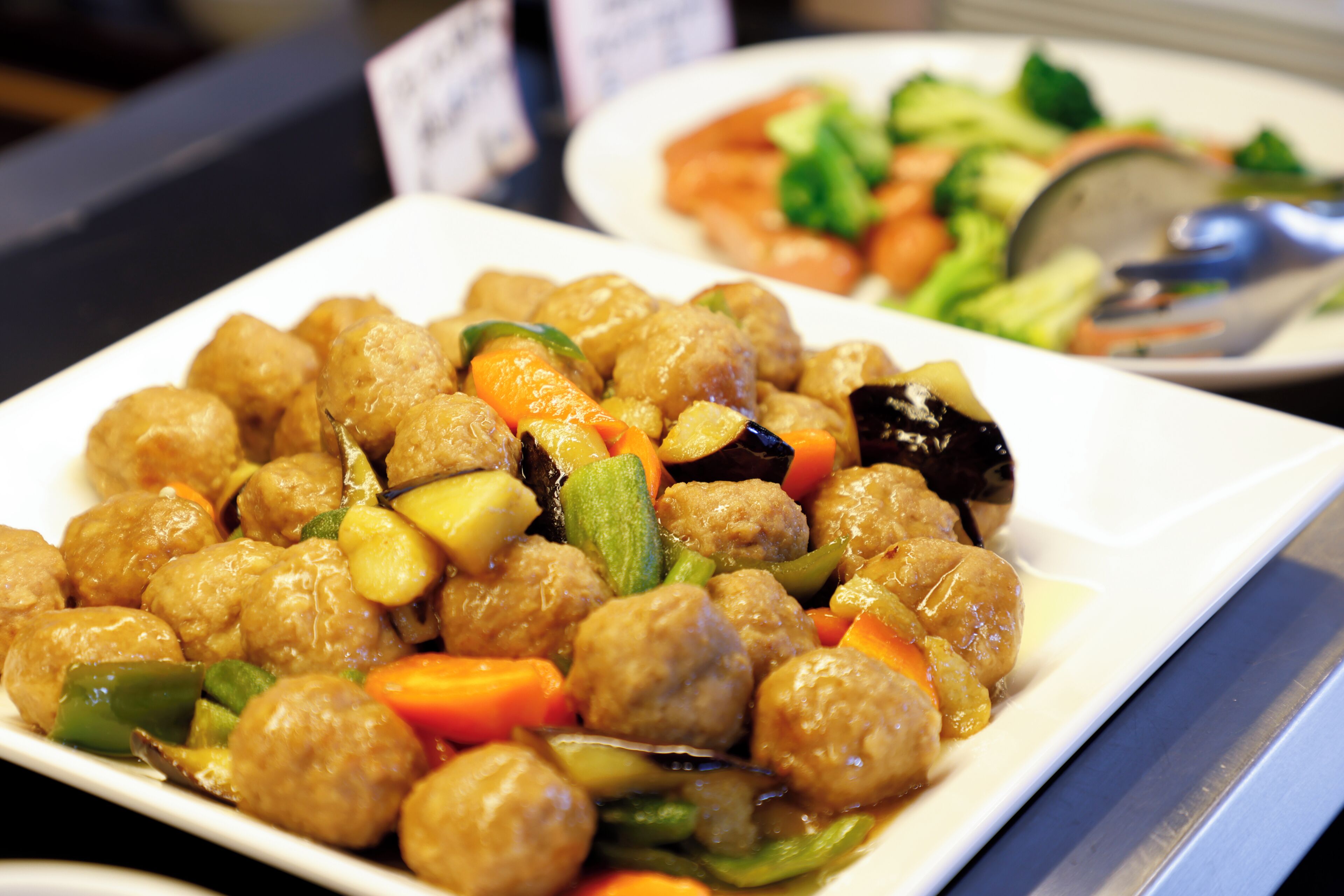 A plate of meatballs with vegetables.