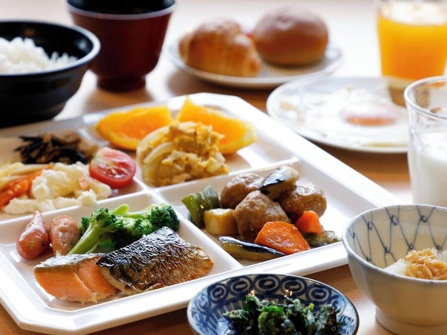Una bandeja con varios platos que incluyen pescado, verduras y arroz.