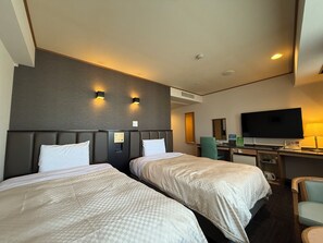 Une chambre d’hôtel avec deux lits, un bureau, une télévision et une chaise.