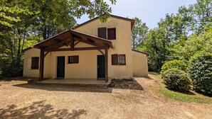 A two-story building with a covered porch, a front door, and a small window. - Quiet house in exceptionally beautiful Holiday Resort **** in Dordogne-Lot (Gavaudun)