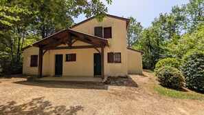 A two-story building with a covered porch, a front door, and a small window. - Quiet house in exceptionally beautiful Holiday Resort **** in Dordogne-Lot (Gavaudun)
