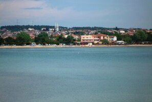 Un pueblo costero con una iglesia destacada, playa y edificios a lo largo de la costa.