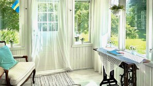 Une pièce chaleureuse avec une chaise en bois, une petite table recouverte d’une nappe en dentelle et une vue sur la verdure à l’extérieur.