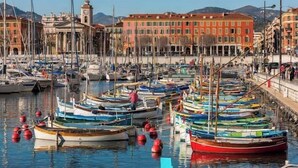 A marina with boats docked, a clock tower, and buildings in the background. - Beautiful for 4 people, town centre, 100 m from the beaches, near the shops (Menton)
