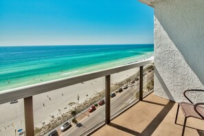 A balcony with a view of a beach and a road.
