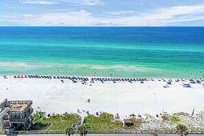 A beach with a boardwalk, beach umbrellas, and a lifeguard tower.