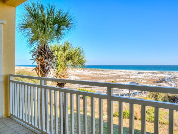 A balcony with a view of a beach and ocean.