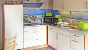 Kompakti keittiö, jossa on mikroaaltouuni, leivänpaahdin ja pesuallas.