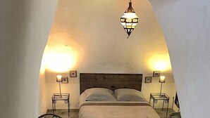 A bedroom with two beds, a wooden headboard, and two wall-mounted lamps. - CORSE HOUSE EXCEPTIONAL SEA VIEW IN A VILLAGE BETWEEN SEA & MOUNTAINS (Speloncato)