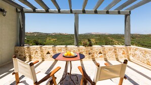 A terrace with a table set for two, overlooking a scenic landscape. - Villa complex nearby Rethymno with stunning countryside views! (Rethymno)