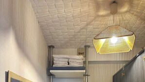 A compact room with a bunk bed, a small wardrobe, a hanging clothes rack, and a framed picture on the wall. - Studio cabine à Arcachon centre, vue imprenable sur le bassin (ARCACHON)