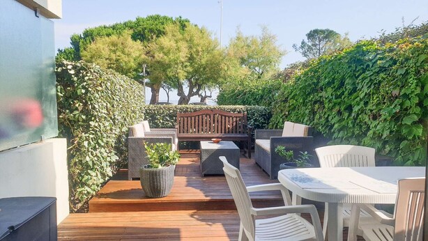 An outdoor patio with wicker furniture, a wooden table, and a bench. - Studio cabine à Arcachon centre, vue imprenable sur le bassin (ARCACHON)