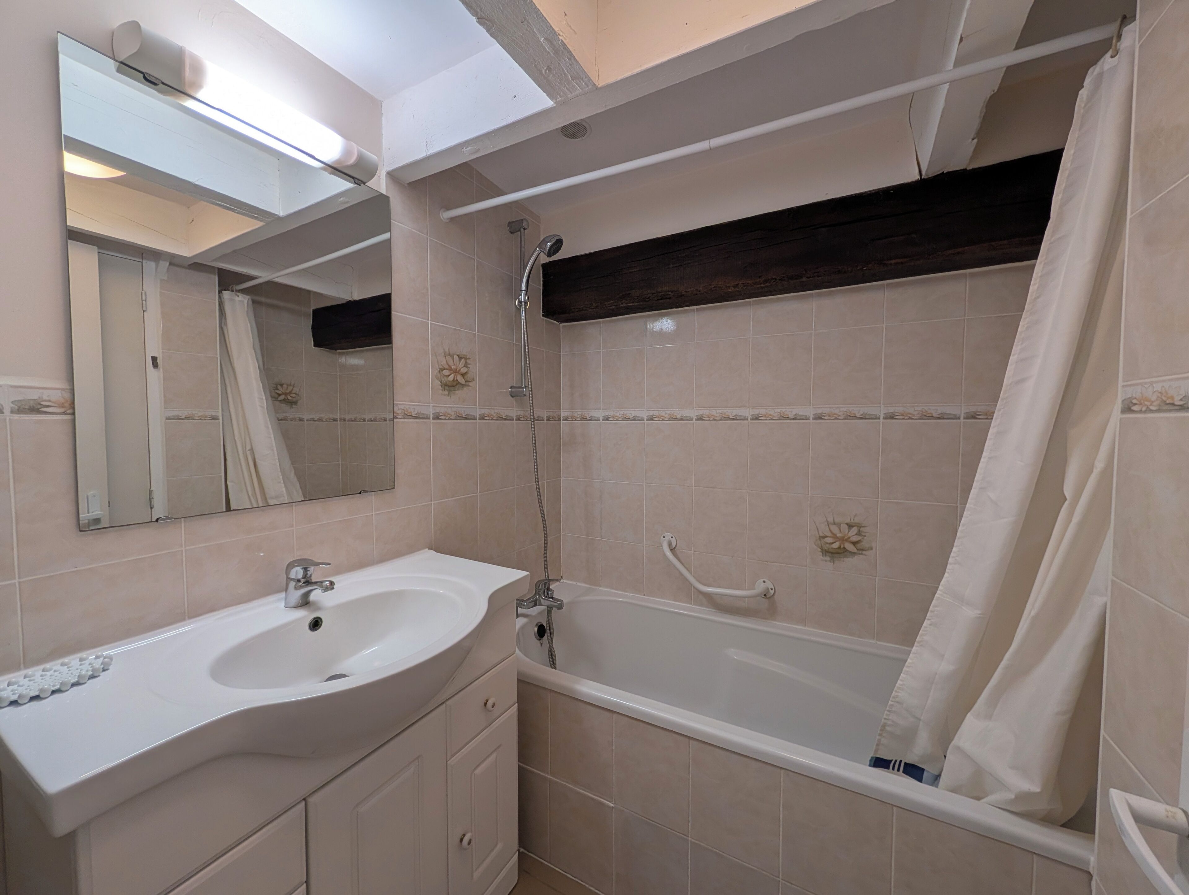 Ein Badezimmer mit Waschbecken, Spiegel, Dusche und Badewanne.