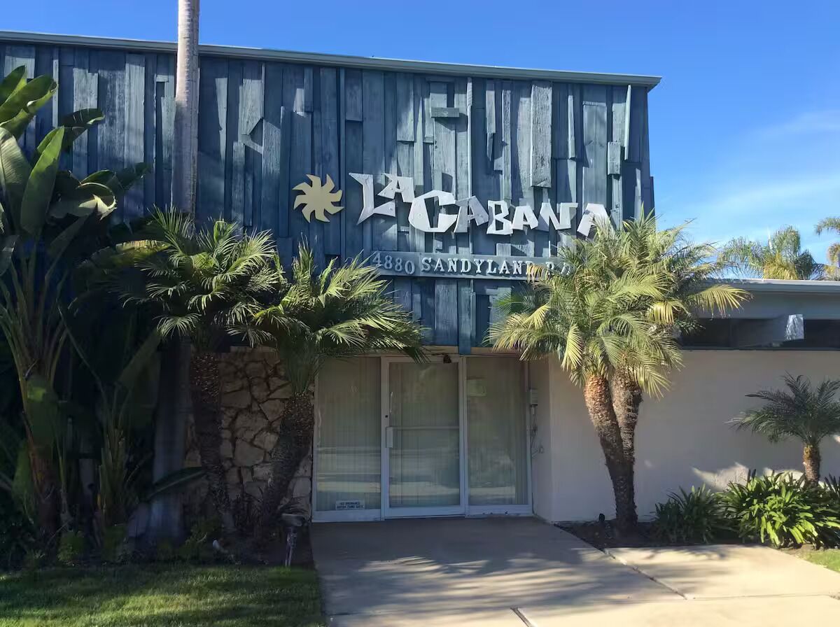 A building with a wooden facade and a sign reading "La Cabana 4880 Sandylane Blvd."