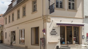 A building with a sign reading "FAHR AWAY" and a signpost with directions. - Weinbar und Hotel FahrAway (Volkach)