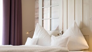A bed with white linens, a window with a wooden frame, and a curtain. - Weinbar und Hotel FahrAway (Volkach)