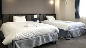 Two single beds with grey headboards and white bedding in a hotel room. - Shiroko Storia Hotel (Suzuka)